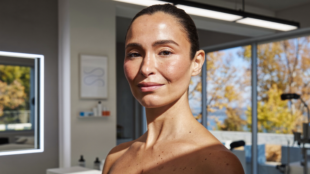Woman in her early forties with healthy sun-kissed skin in soft autumn light at a skincare clinic